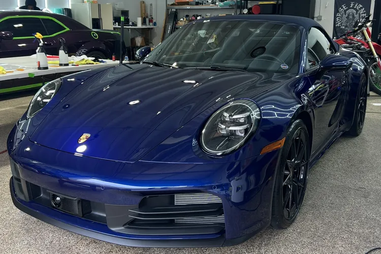 Illustrative 100% VLT shade comparison on a blue Porsche; not a measured installation